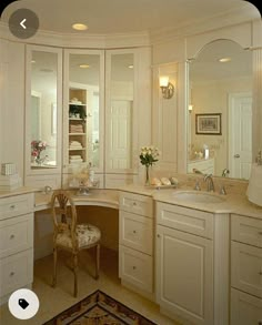 a large bathroom with white cabinets and mirrors