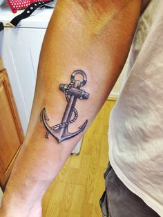 an anchor tattoo on the arm of a man