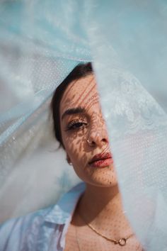 a woman with freckles on her face and veil over her head