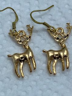 SHIP WITHIN US ONLY THXThese little gold color deer charms are simple, but eye catching.  I added gold plate ear wires. Everything I use is  marked nickel free.  These are new hand-crafted Local regulations do not allow returns or exchanges on pierced jewelry  I ship daily via 1st class mail with trackingPLEASE NOTE:  I only ship within the USA   Current postal rates  and lack of reliable tracking on international orders makes it impossible   Thank you for understandingPLEASE NOTE   I do not shi Gold Earrings For Winter Holiday, Gold Earrings For Holiday Season, Holiday Gold Earrings With Ear Wire, Gold Earrings With Ear Wire For Holidays, Gold Dangle Earrings For Holiday, Gold Drop Earrings For Holiday, Handmade Gold Christmas Earrings, Handmade Gold Earrings For Christmas, Gold Dangle Earrings For Christmas