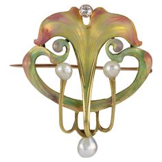 An Art Nouveau enamel, pearl and diamond brooch, with opalescent shaded enamel sinuous curling leaves in pale pink, green and gold, set on the top with an old-cut diamond estimated to weigh 0.15 carats and flanked with three natural freshwater pearls, all made in yellow gold, circa 1900, measuring approximately 4.3 x 3.6cm, the pin measuring approximately 3.9cm long, gross weight 9.2 grams. This elegant brooch is emblematic of graceful Art Nouveau design in its elegant curving lines and shapes. Design Art Nouveau, Floral Watches, Bijoux Art Nouveau, Art Nouveau Pendant, Art Nouveau Design, Art Nouveau Jewelry, Diamond Brooch, Pin Pendant, Gold Art