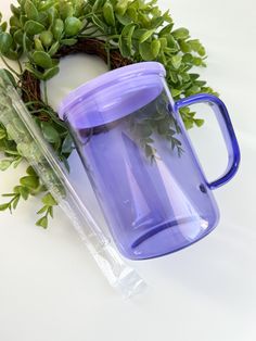 a purple coffee mug sitting next to a wreath