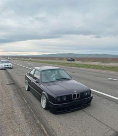 two cars are driving down the highway in front of another car on the other side