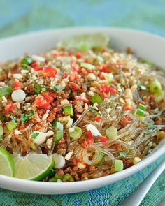 a white bowl filled with rice and veggies on top of a blue table cloth