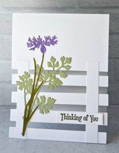 a white card with purple flowers and the words thinking of you written in black ink