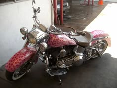 a pink and black motorcycle parked in front of a building