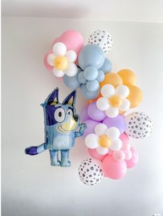 balloons are arranged in the shape of cartoon characters and flowers on a white wall background