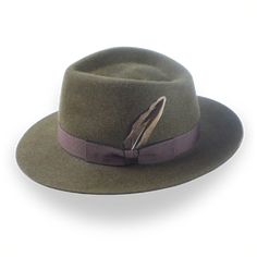 Description Materials Craftsmanship Hat Care Shipping Returns Product Description A Unique Melange Fur Felt Fedora Step into style with the Storyteller, an army green wide-brim fedora handcrafted from luxurious melange rabbit fur felt. Featuring a 5" teardrop crown and a 2 5/8" raw-edge snap brim, this fedora offers a perfect balance of refined elegance and rugged durability. Custom-made to fit your exact size, the Storyteller includes a pecan grosgrain ribbon hatband, viscose satin lining, and Homburg Hat, 1940 Style, Outdoor Hut, Green Rabbit, The Storyteller, Mens Hats Fashion, Fedora Hat Men, Homburg, Chapeau Cowboy