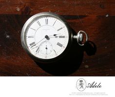 an old pocket watch sitting on top of a wooden table