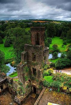 an aerial view of the ruins of a castle with green fields and trees in the background