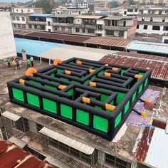 an inflatable trampoline maze on top of a building with people standing around it