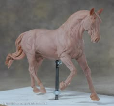 a toy horse is standing on top of a pole and has its legs spread out