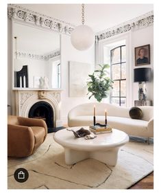 a living room filled with furniture and a fire place in front of a mirror on the wall