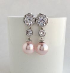 Simply gorgeous !! I've created these elegant cubic zirconia and Swarovski pearl bridal earrings in rhodium plated brass setting. Earrings feature large 12mm Swarovski Blush Pink pearls that dangle from brilliant cut clear cubic zirconia with halo setting 12mm ear stud and round connector. Halo setting gives a brilliantly beautiful effect. Total length of the earrings is 3.8 cms. For matching necklace click: https://www.etsy.com/listing/761211024/large-pink-pearl-bridal-necklace-blush?ref=shop_h Elegant Pink Crystal Bridal Earrings, Pink Pearl Drop Bridal Earrings For Wedding, Pink Pearl Bridal Earrings For Wedding, Pink Pearl Drop Earrings For Wedding, Pink Pearl Earrings For Wedding, Elegant Pink Cubic Zirconia Bridal Earrings, Wedding Cubic Zirconia Round Pearl Earrings, Round Cubic Zirconia Pearl Earrings For Wedding, Wedding Round Cubic Zirconia Pearl Earrings