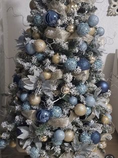 a decorated christmas tree with blue and gold ornaments