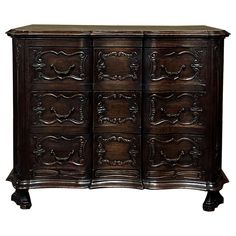 an old wooden dresser with many drawers and carvings on the front, in dark wood