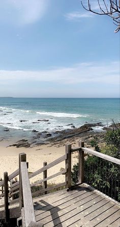 a wooden bench sitting on top of a beach next to the ocean