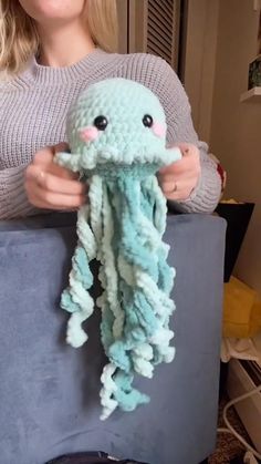 a woman holding an octopus stuffed animal in her hands