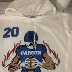 a white hoodie with an image of a football player holding a ball on it