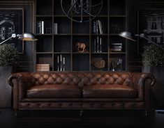 a living room with leather couches and bookshelves on the wall next to a lamp