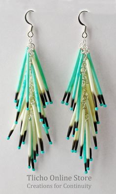 the earrings are decorated with black, white and green beads on them'dangles