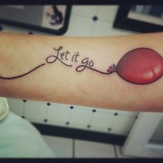 a person with a tattoo on their arm that says let it go and an apple