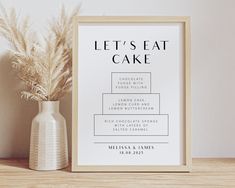 a white framed poster with the words let's eat cake on it next to a potted plant