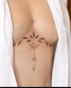 a woman's breast with an arrow tattoo on her left side, and stars in the middle