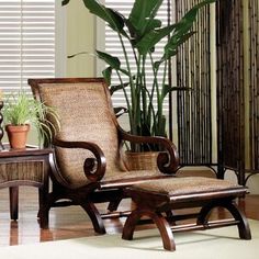 a chair and ottoman in front of a plant