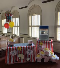 two tables with popcorn and balloons on them