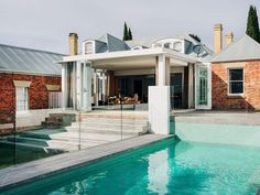 a house with a pool in front of it and some stairs leading up to the roof