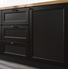 a kitchen with black cabinets and wood counter tops