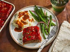 a plate with meatloaf, mashed potatoes and green beans