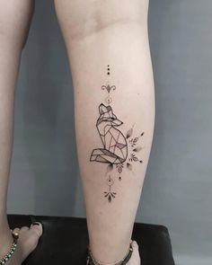 a woman's leg with a tattoo on it that is shaped like a fox