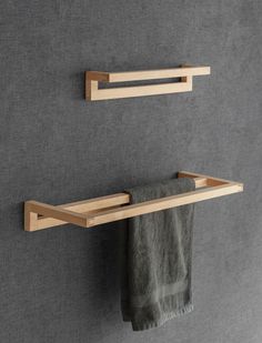 two wooden shelves on the wall with towels hanging from them