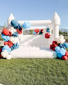 an inflatable bed with balloons and flowers on the back is set up for a party