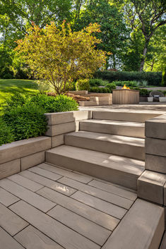 an outdoor patio with steps leading up to the trees and bushes in the back yard