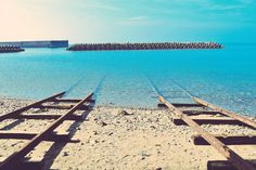 an old train track sitting on the beach