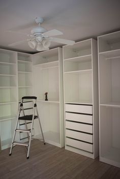 a ladder is standing in front of some white closets with drawers and shelving