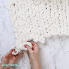 someone is making a crocheted blanket out of yarn