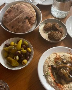 a table topped with plates and bowls filled with different types of food on top of it