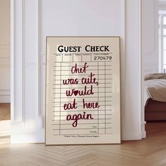 a poster with the words guest check written in red on it next to a bed