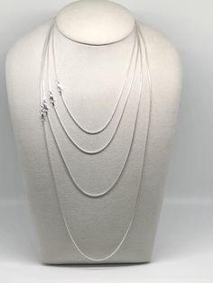 Featuring a smooth, fluid look and bright finish, this round sterling silver seamed snake chain necklace is a great option for pendants that benefit from a strong, slender chain. Seamed snake chain is created with soldered, machine-made curb-style chain that is compressed twice, producing the snake-like appearance and leaving behind a telltale seam visible along its length. This chain is plated with fine silver to ensure a bright white color and to help protect against tarnish. A lovely chain to Silver Snake Chain Necklace With Delicate Chain, Silver Snake Chain Jewelry With Delicate Chain, Silver Snake Chain Jewelry, Sterling Silver Delicate Snake Chain Necklace Gift, Sterling Silver Snake Chain Jewelry, Sterling Silver Necklace With Delicate Snake Chain, Silver Snake Chain Necklace With Adjustable Chain, Elegant Sterling Silver Snake Chain Necklace With Adjustable Chain, White Gold Sterling Silver Snake Chain Necklace