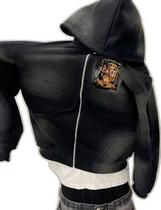 a person wearing a black jacket with a hoodie on it's back and an image of a hogwarts crest