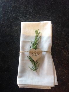 a folded white napkin with a heart on it and the word will written on it