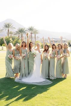 a group of women standing next to each other on top of a lush green field