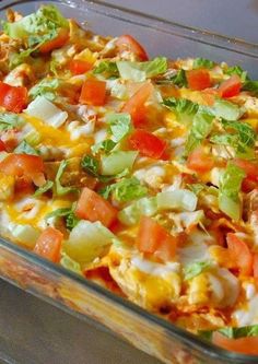 a casserole dish with lettuce, tomatoes and other vegetables in it