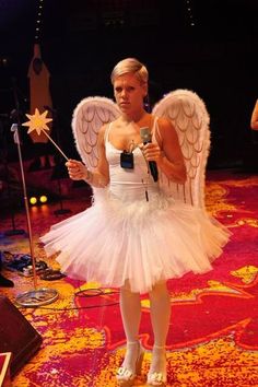 a woman dressed as an angel holding a microphone