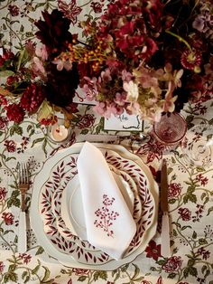 a table set with place settings and flowers