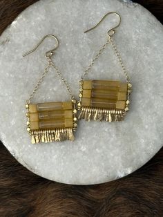 The "Carmine" earring is very gift-able and a classic accessory to add a little something special to the every day- that easily goes from day to night and looks with any hair color. They're light toward medium weighted and have great movement from hand-forged gold fringe.  Handcrafted Specifics: Stone: yellow fluroite tube beads and yellow jade cube beads Other materials: brass plated multi-faceted beads, gold chain with hand-forged gold fringe. Gold filled Ear wire/Fish hook  Weight/feel: mediu Rectangular Gold Artisan Jewelry, Artisan Rectangular Gold Jewelry, Unique Yellow Dangle Jewelry, Artisan Gold Earrings With Dangling Beads, Artisan Yellow Jewelry With Dangling Beads, Yellow Gold Chain Brass Earrings, Artisan Yellow Dangle Earrings, Artisan Gold Long Drop Earrings, Gold Chain Dangle Brass Earrings